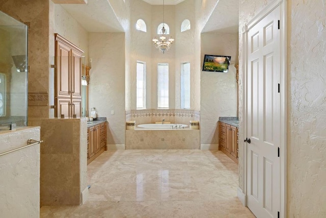 11209 Macaw Ct, Windermere, FL 34786 - bathroom with a textured wall, vanity, a bath, marble tiled floors, and a chandelier