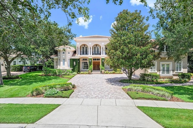 11209 Macaw Ct, Windermere, FL 34786 - mediterranean / spanish-style house with french doors, decorative driveway, a front lawn, and stucco siding