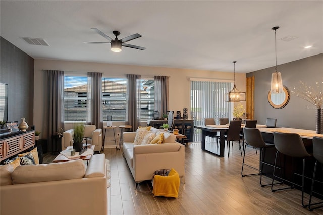 6992 Dilly Lake Ave, Groveland, FL 34736 - living room featuring ceiling fan, wood finished floors, and a chandelier