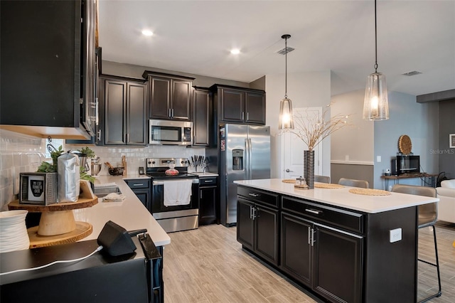 6992 Dilly Lake Ave, Groveland, FL 34736 - kitchen featuring stainless steel appliances, light countertops, a breakfast bar area, backsplash, and decorative light fixtures