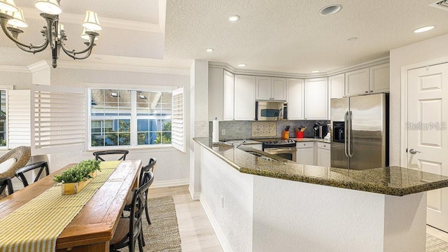 7650 Whisper Way Unit 304, Reunion, FL 34747 - kitchen featuring stainless steel appliances, crown molding, dark stone countertops, a chandelier, and backsplash