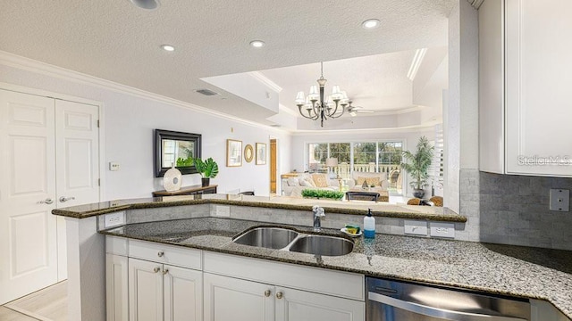 7650 Whisper Way Unit 304, Reunion, FL 34747 - kitchen featuring ornamental molding, dark stone countertops, a chandelier, a textured ceiling, and tasteful backsplash