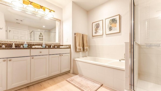 7650 Whisper Way Unit 304, Reunion, FL 34747 - full bathroom with a shower stall, double vanity, a garden tub, and wood finished floors