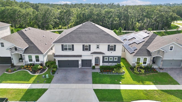 4477 Renly Ln, Clermont, FL 34711 - view of front of property featuring stucco siding, decorative driveway, an attached garage, stone siding, and a shingled roof