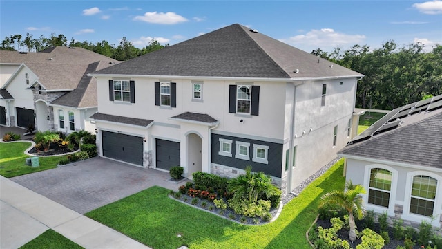 4477 Renly Ln, Clermont, FL 34711 - view of front of property with stucco siding, a garage, decorative driveway, stone siding, and a front yard