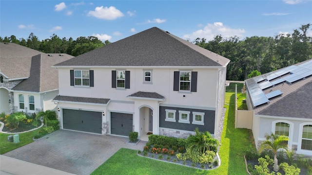 4477 Renly Ln, Clermont, FL 34711 - view of front of home featuring an attached garage, stucco siding, stone siding, decorative driveway, and a front lawn