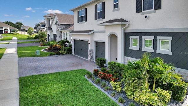 4477 Renly Ln, Clermont, FL 34711 - traditional-style home with stucco siding, a garage, decorative driveway, a front yard, and a residential view