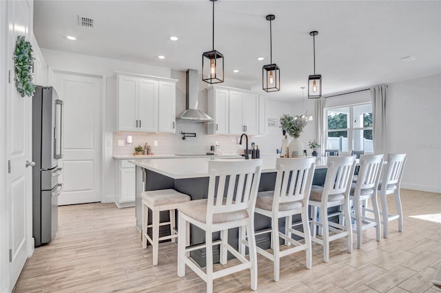 4477 Renly Ln, Clermont, FL 34711 - kitchen with wall chimney exhaust hood, freestanding refrigerator, tasteful backsplash, light wood finished floors, and recessed lighting