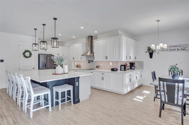 4477 Renly Ln, Clermont, FL 34711 - kitchen featuring high quality fridge, wall chimney range hood, a chandelier, black electric stovetop, and decorative backsplash