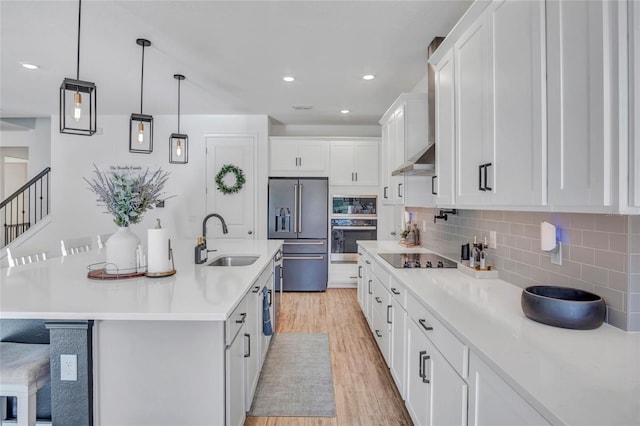 4477 Renly Ln, Clermont, FL 34711 - kitchen with appliances with stainless steel finishes, light wood finished floors, white cabinetry, decorative backsplash, and light countertops