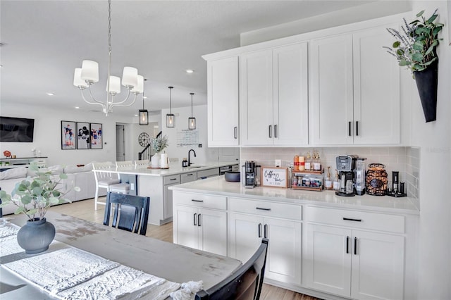4477 Renly Ln, Clermont, FL 34711 - kitchen featuring open floor plan, a chandelier, tasteful backsplash, white cabinets, and a peninsula