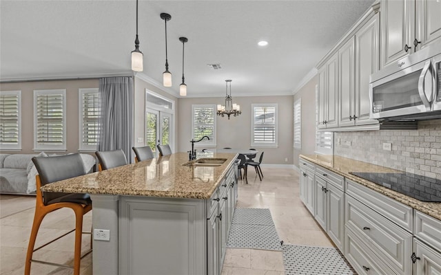 12023 Gold Creek Trl, Windermere, FL 34786 - kitchen featuring stainless steel microwave, a kitchen breakfast bar, crown molding, black electric stovetop, and tasteful backsplash