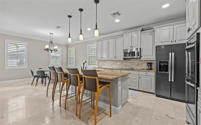 12023 Gold Creek Trl, Windermere, FL 34786 - kitchen with appliances with stainless steel finishes, crown molding, backsplash, healthy amount of natural light, and a chandelier