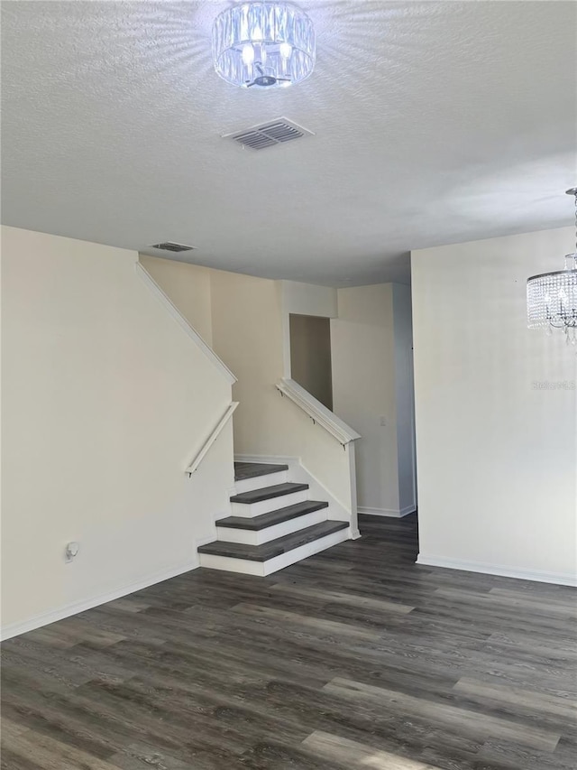 1954 Marabou Dr, Davenport, FL 33896 - below grade area with a chandelier, stairway, dark wood-type flooring, and a textured ceiling