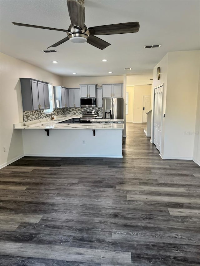 1954 Marabou Dr, Davenport, FL 33896 - kitchen featuring stainless steel appliances, a peninsula, light countertops, a breakfast bar, and recessed lighting
