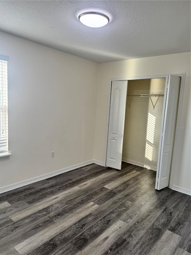 1954 Marabou Dr, Davenport, FL 33896 - unfurnished bedroom with dark wood-style flooring, a closet, and a textured ceiling