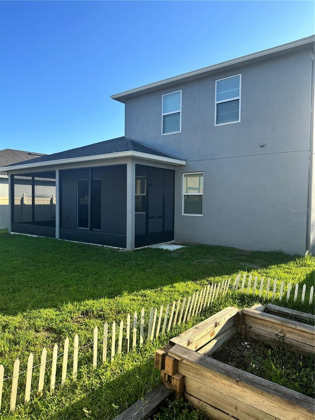1954 Marabou Dr, Davenport, FL 33896 - back of property featuring a yard, a vegetable garden, a sunroom, and stucco siding