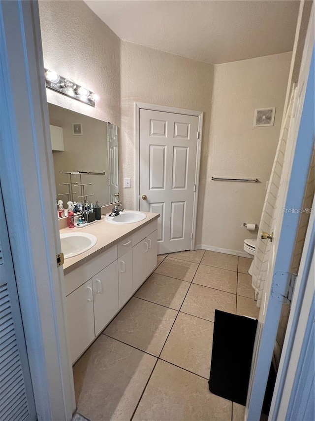 3593 Conroy Rd Unit 416, Orlando, FL 32839 - bathroom with double vanity, tile patterned floors, and a textured wall