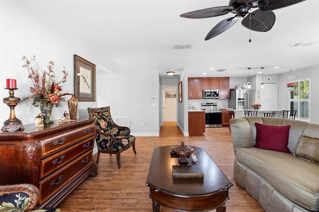 43 Pergola Pl, Ormond Beach, FL 32174 - living room with light wood finished floors, a ceiling fan, and a textured ceiling