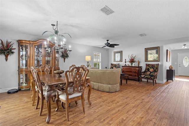43 Pergola Pl, Ormond Beach, FL 32174 - dining space with light wood finished floors, a textured ceiling, a ceiling fan, and a chandelier