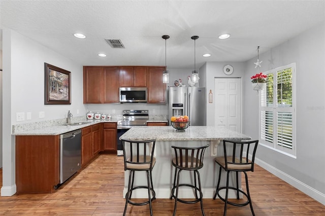 43 Pergola Pl, Ormond Beach, FL 32174 - kitchen featuring appliances with stainless steel finishes, light wood-style flooring, a kitchen bar, a kitchen island, and recessed lighting