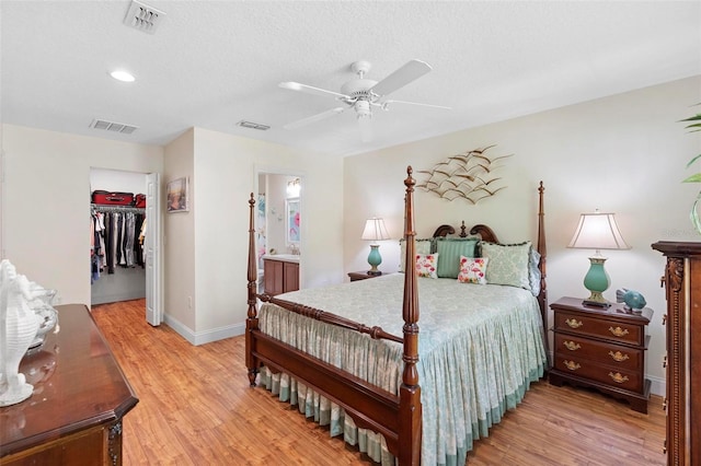 43 Pergola Pl, Ormond Beach, FL 32174 - bedroom featuring light wood finished floors, ensuite bathroom, ceiling fan, recessed lighting, and a textured ceiling