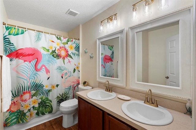 43 Pergola Pl, Ormond Beach, FL 32174 - bathroom with double vanity, a textured ceiling, wood finished floors, and a shower with curtain