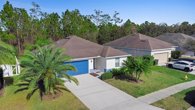 43 Pergola Pl, Ormond Beach, FL 32174 - view of front of property featuring an attached garage, stucco siding, concrete driveway, a front yard, and roof with shingles