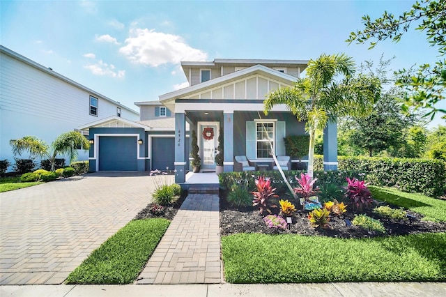6926 Cucamelon Ct, Windermere, FL 34786 - view of front of property with decorative driveway, covered porch, a garage, and board and batten siding