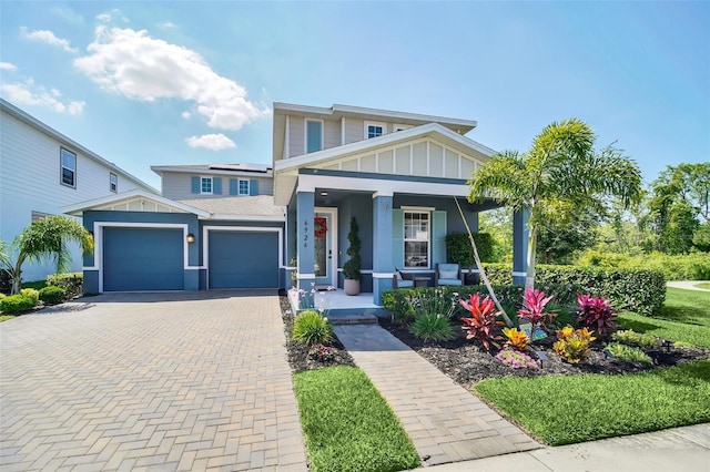 6926 Cucamelon Ct, Windermere, FL 34786 - view of front facade featuring a porch, decorative driveway, solar panels, board and batten siding, and an attached garage