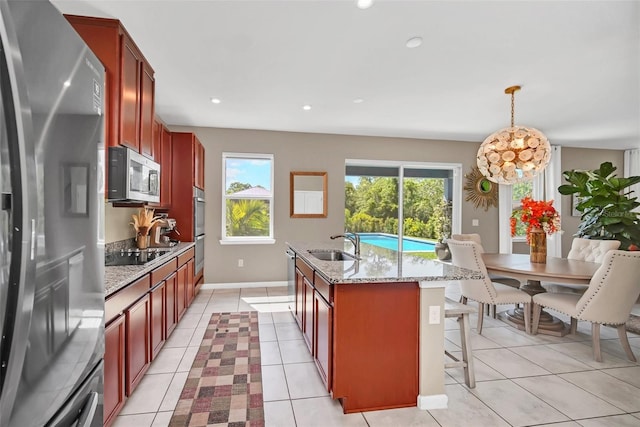 6926 Cucamelon Ct, Windermere, FL 34786 - kitchen with stainless steel appliances, a center island with sink, light stone countertops, a breakfast bar area, and recessed lighting