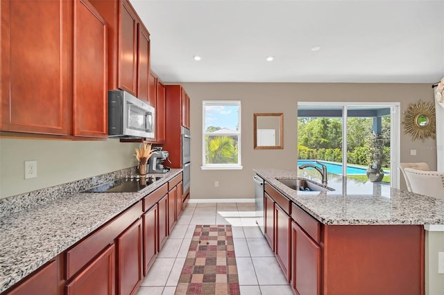 6926 Cucamelon Ct, Windermere, FL 34786 - kitchen featuring a kitchen island with sink, light tile patterned floors, stainless steel appliances, light stone counters, and recessed lighting