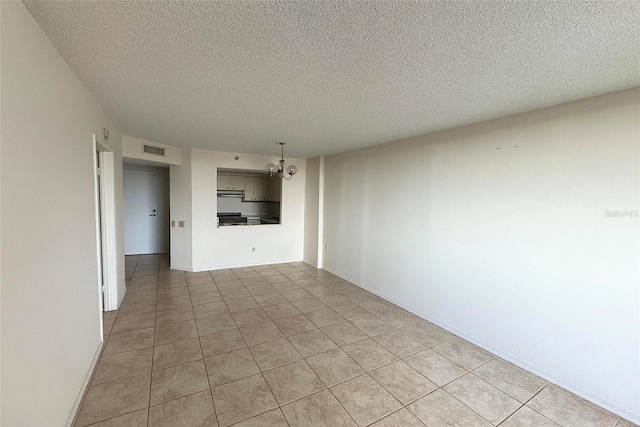 2333 Feather Sound Dr Unit C509, Clearwater, FL 33762 - spare room featuring a chandelier, a textured ceiling, and light tile patterned flooring