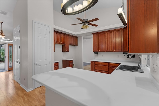 10642 Masters Dr, Clermont, FL 34711 - kitchen with high vaulted ceiling, a ceiling fan, light wood-type flooring, a peninsula, and light countertops