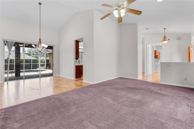 10642 Masters Dr, Clermont, FL 34711 - unfurnished room with carpet floors, a chandelier, a ceiling fan, high vaulted ceiling, and wood finished floors