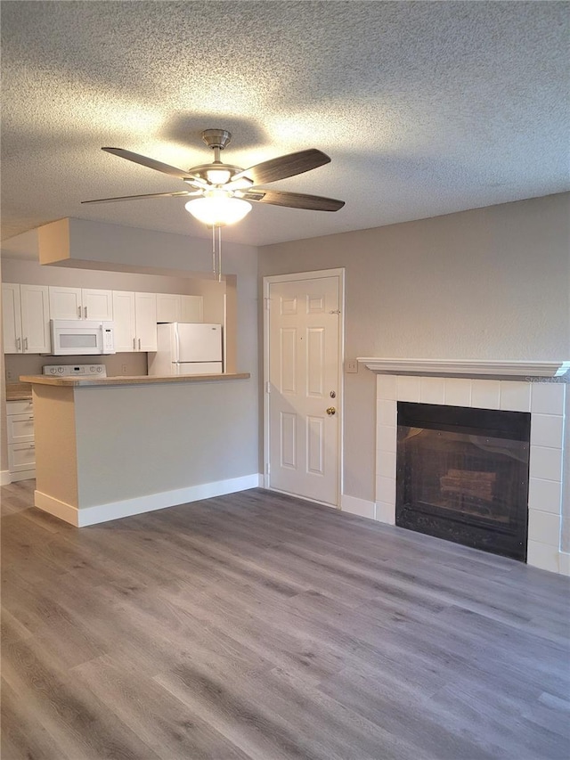 4400 Thornbriar Ln Unit A103, Orlando, FL 32822 - unfurnished living room featuring ceiling fan, a fireplace, a textured ceiling, and wood finished floors