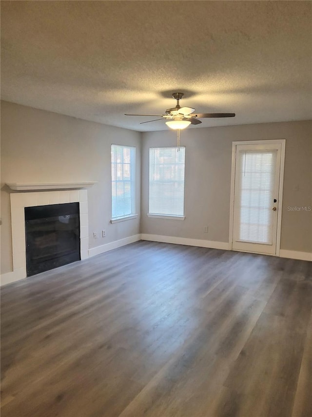 4400 Thornbriar Ln Unit A103, Orlando, FL 32822 - unfurnished living room featuring wood finished floors, a fireplace, a ceiling fan, and a textured ceiling