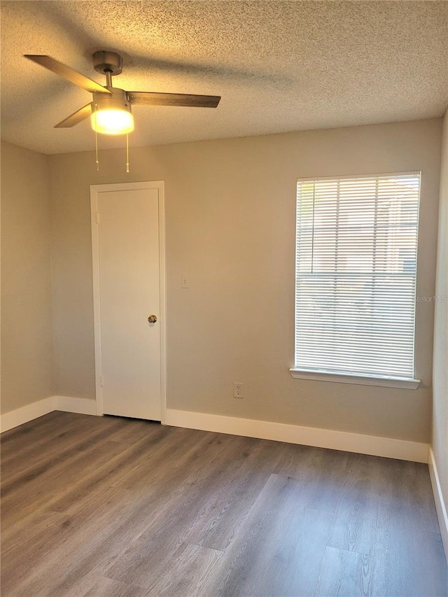 4400 Thornbriar Ln Unit A103, Orlando, FL 32822 - unfurnished room featuring dark wood-type flooring, a ceiling fan, plenty of natural light, and a textured ceiling