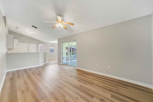 938 Gateshead Ct, Kissimmee, FL 34758 - unfurnished living room with a ceiling fan, lofted ceiling, light wood finished floors, and a textured ceiling