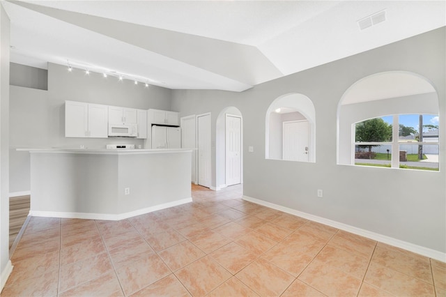 938 Gateshead Ct, Kissimmee, FL 34758 - kitchen featuring lofted ceiling, track lighting, white appliances, white cabinets, and light tile patterned floors