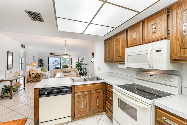 4570 Ocean Beach Blvd Unit 226, Cocoa Beach, FL 32931 - kitchen with white appliances, light tile patterned flooring, a peninsula, brown cabinets, and open floor plan