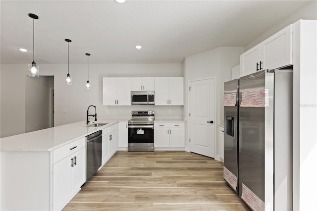 764 Marion Oaks Mnr, Ocala, FL 34473 - kitchen with stainless steel appliances, a peninsula, light wood-style flooring, recessed lighting, and white cabinetry