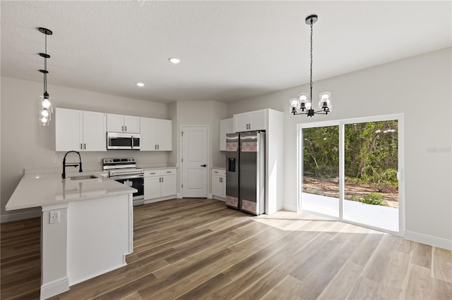 764 Marion Oaks Mnr, Ocala, FL 34473 - kitchen with stainless steel appliances, a peninsula, light wood finished floors, light countertops, and white cabinetry