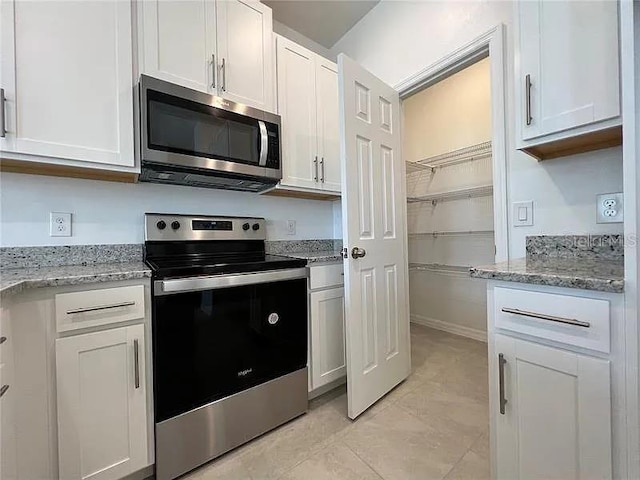 2343 Garden Belle Dr, Clermont, FL 34711 - kitchen featuring appliances with stainless steel finishes, light stone countertops, and white cabinets