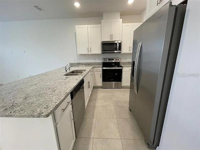 2343 Garden Belle Dr, Clermont, FL 34711 - kitchen featuring appliances with stainless steel finishes, a peninsula, white cabinetry, light stone counters, and recessed lighting