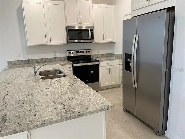 2343 Garden Belle Dr, Clermont, FL 34711 - kitchen featuring stainless steel appliances, light stone counters, white cabinetry, and a peninsula