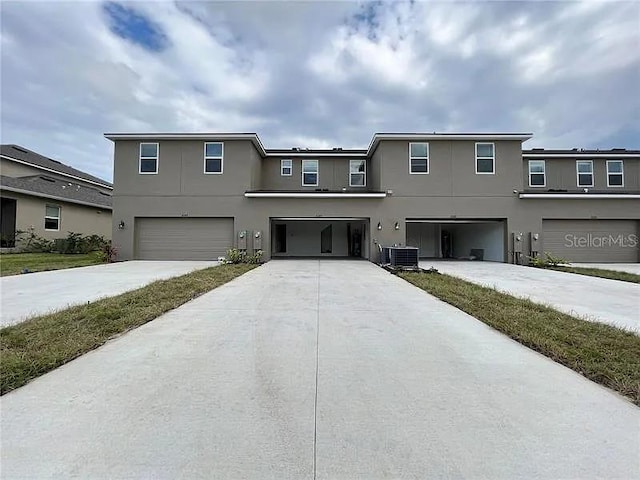 2343 Garden Belle Dr, Clermont, FL 34711 - traditional home featuring stucco siding, an attached garage, and driveway