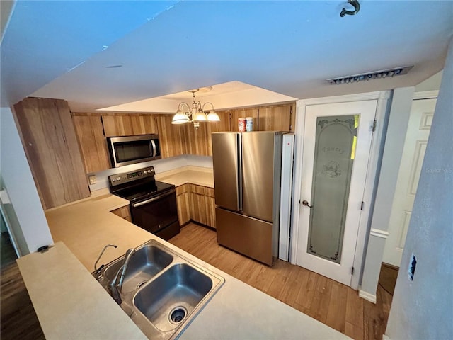 8131 Braddock Cir Unit 1, Port Richey, FL 34668 - kitchen featuring appliances with stainless steel finishes, light wood-style flooring, light countertops, and brown cabinetry