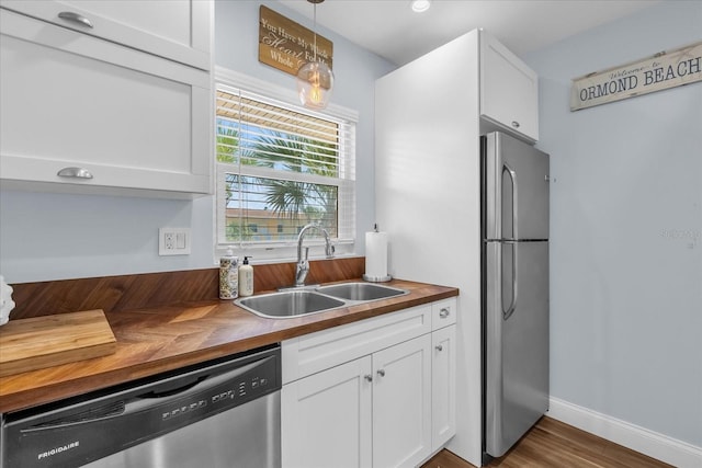 2790 Ocean Shore Blvd Unit 8N, Ormond Beach, FL 32176 - kitchen with wood counters, stainless steel appliances, white cabinetry, hanging light fixtures, and dark wood-style floors