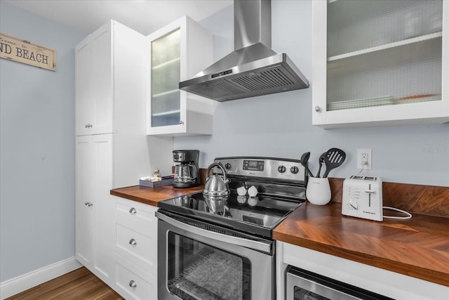 2790 Ocean Shore Blvd Unit 8N, Ormond Beach, FL 32176 - kitchen with butcher block countertops, stainless steel appliances, wall chimney exhaust hood, and white cabinetry